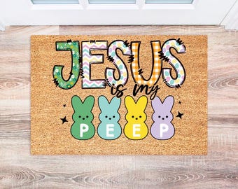 May include: A brown coir doormat with the text "Jesus is my Peep" in colorful letters. Four pastel-colored marshmallow chicks are below the text.