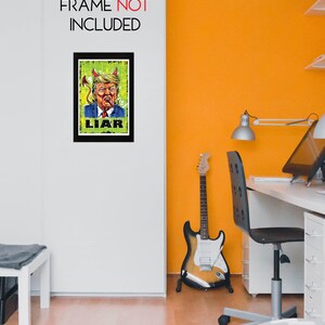 May include: A framed art print with a satirical illustration of a man with devil horns and a cigar, the word "LIAR" is below the image. The text "FRAME NOT INCLUDED" is above the frame. The artwork is displayed on a white wall.