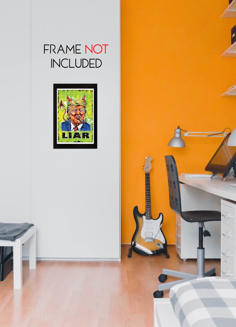 May include: A framed art print with a satirical illustration of a man with devil horns and a cigar, the word "LIAR" is below the image. The text "FRAME NOT INCLUDED" is above the frame. The artwork is displayed on a white wall.