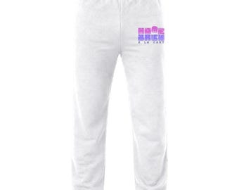 May include: Light gray sweatpants featuring an elastic waistband and cuffed ankles. On the upper right thigh, there is a graphic print with the text "HOME BREW" in a pink to purple gradient, with the smaller text "À LA CART" printed below it.