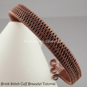 May include: A copper wire bracelet with a brick stitch pattern. The bracelet is on a white surface and has a decorative swirl at the end.