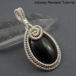 May include: A silver wire wrapped pendant featuring a black oval gemstone. The pendant has a spiral design at the top and is attached to a silver bail.