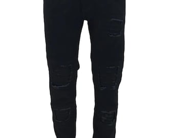 Könnte beinhalten: Schwarze, ausgefranste Jeans aus Denim mit mehreren Rissen und Löchern an den Beinen.
