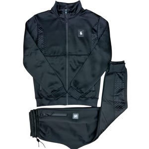 May include: A black tracksuit with a zip-up jacket and matching trousers. The jacket has a small logo on the left chest and the trousers have a logo on the right leg.
