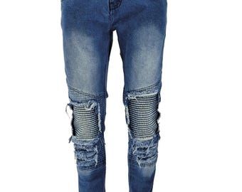 May include: Blue denim jeans with distressed details and knee pads. The jeans have a slim fit and a faded wash.