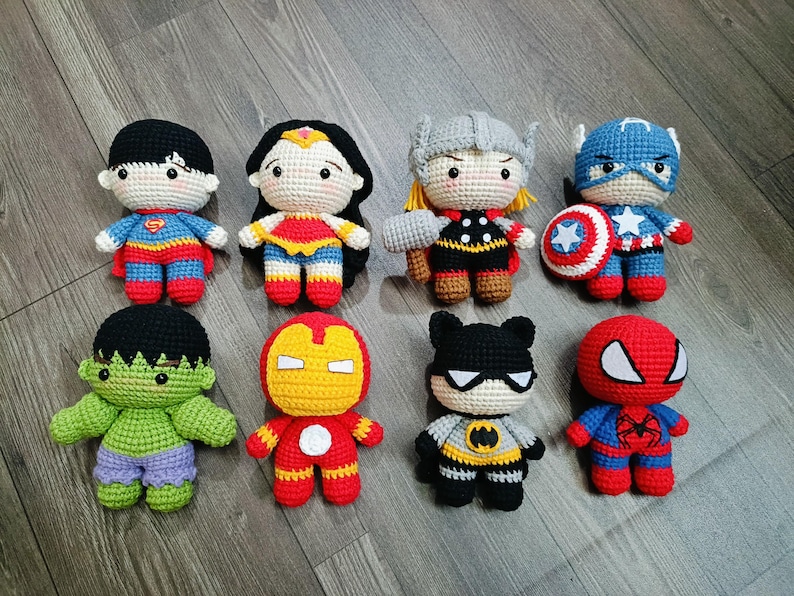 May include: A collection of eight crocheted superhero characters, including Superman, Wonder Woman, Thor, Captain America, Hulk, Iron Man, Batman, and Spiderman. Each character is unique and detailed, with recognizable features and accessories.