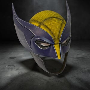Puede incluir: Una m&aacute;scara estilo Wolverine, con una parte superior texturizada amarilla y negra, y detalles en azul y gris. La m&aacute;scara tiene extensiones puntiagudas en forma de orejas y aberturas para los ojos. La m&aacute;scara est&aacute; hecha de un material duradero.