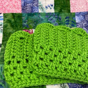 Puede incluir: Dos cuadrados de crochet de color verde lima brillante. Los cuadrados están hechos con un patrón de punto simple y tienen una superficie ligeramente texturizada.