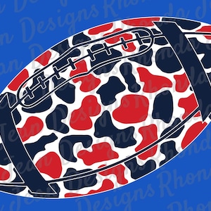 Peut inclure: Un ballon de football avec un motif de vache rouge, marine et blanc. Le ballon a des rayures et des coutures marine. Le fond est de couleur bleu uni. Le texte "Rhonda Jean Designs" est en arrière-plan.