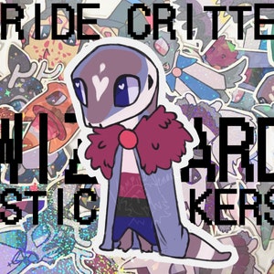 May include: A sticker sheet featuring a cartoon critter with a heart on its forehead, wearing a red bow and a blue and black cape. The critter is surrounded by other stickers with various designs, including hearts, stars, and rainbows. The text "PRIDE CRITTER STICKERS" is printed in black at the top of the sheet.