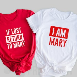 Könnte beinhalten: Zwei T-Shirts, eines rot und eines weiß, mit einem passenden Partner-Design. Das rote Shirt sagt "Wenn verloren, zurück zu Mary" in weißer Schrift. Das weiße Shirt sagt "Ich bin Mary" in roter Schrift.