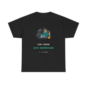 May include: A black t-shirt featuring a graphic of a person and a robot working at a keyboard with a yellow rubber duck. The text reads VIBE CODING WITH SUPERVISION and includes smaller text below that says FP_ // BUILT REFFERENT_.