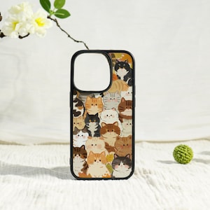 May include: A black phone case featuring a repeating pattern of cartoon cats in various colors, including orange, brown, black, and white. The case has a black border and a cutout for the camera.