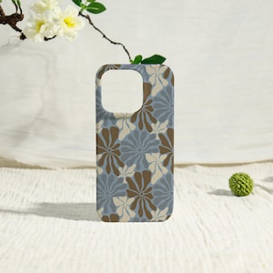 May include: A rectangular phone case featuring a repeating floral pattern in shades of dusty blue, dark brown, and cream. The design consists of stylized, rounded flower shapes arranged across the entire surface, with a square camera cutout.