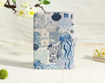 May include: A rectangular e-reader case featuring a collage of blue and white illustrations, including various seashells, a large jellyfish, palm trees, and surfboards. The design is composed of multiple square and rectangular panels with a nautical theme.