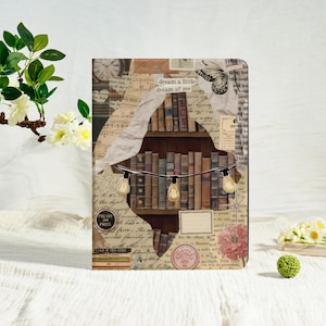 May include: A decorative journal with a collage design featuring a bookshelf, vintage paper, and string lights. The journal has the text "dream a little dream of me" and "POETRY AND PROSE". The cover is a mix of beige, brown, and cream colours.