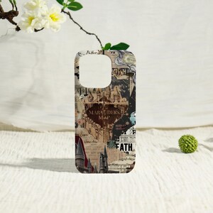 May include: A phone case featuring a collage design with text and illustrations. The case has a cutout for the camera and is decorated with a map design, including the words "Marauders Map" and "Fath". The color scheme is primarily brown and beige.