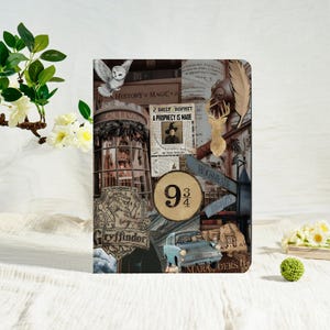 May include: A decorative notebook featuring a collage of images and text from the Harry Potter series. The design includes a white owl, the number 9 3/4, and the words "Gryffindor" and "Hogsmeade". A light blue car is also visible.