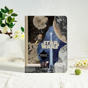 May include: A Star Wars themed notebook with a collage design. The cover features the Star Wars logo, space scenes, and characters. Text includes "There is only the Force" and "You underestimate my power."