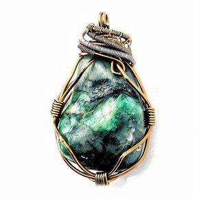 May include: A green gemstone pendant wrapped in copper wire. The pendant is teardrop shaped and has a natural, rough texture.