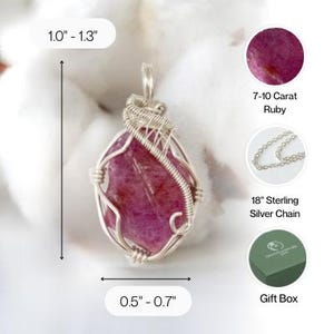 May include: A wire-wrapped pendant featuring a raw, deep pink ruby gemstone. The pendant measures 1.0 to 1.3 inches in height and 0.5 to 0.7 inches in width. It includes a 7-10 carat ruby, an 18-inch sterling silver chain, and a green gift box.