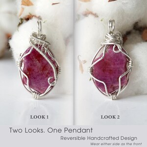 May include: A reversible pendant featuring a raw, deep pink gemstone encased in silver-colored wire wrapping. The image displays two distinct sides labeled Look 1 and Look 2, with the text Two Looks. One Pendant. Reversible Handcrafted Design.
