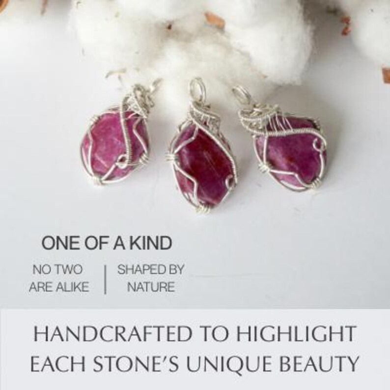 May include: Three wire-wrapped pendants featuring raw, deep pink stones secured in silver-toned metal wire. The image includes the text: ONE OF A KIND, NO TWO ARE ALIKE, SHAPED BY NATURE, HANDCRAFTED TO HIGHLIGHT EACH STONE'S UNIQUE BEAUTY.