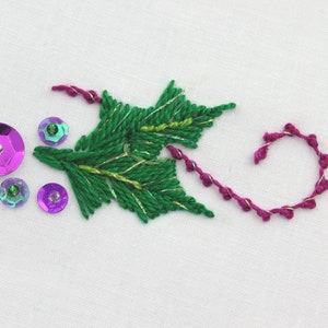 May include: Embroidered green holly leaf with gold thread accents and pink and purple sequins.