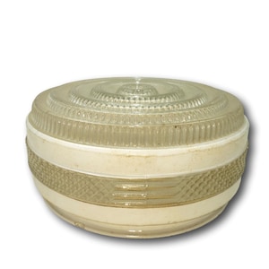May include: A vintage, round light fixture with a clear, ribbed glass top and a cream-colored base. The base features a decorative, geometric pattern. The fixture is designed to be mounted on a ceiling and provides ambient lighting.