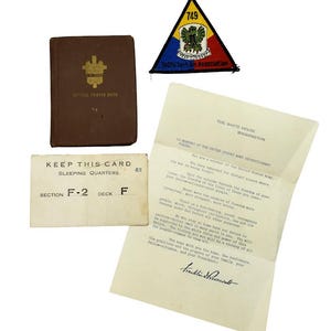 May include: A collection of military memorabilia including a brown Service Prayer Book, a triangular 749th Tank Bn Association patch, a cream-coloured sleeping quarters card labelled Section F-2 Deck F, and a White House letter signed by Franklin Roosevelt.