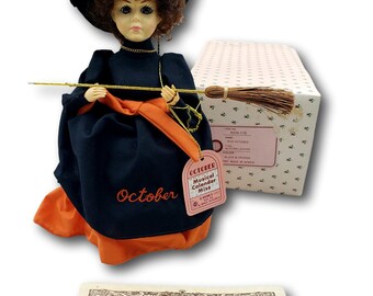 Bambola vintage "Musical Calendar Miss" di Brinn – Miss Ottobre – Foglie autunnali – Costume da strega – Scatola e certificato di autenticità