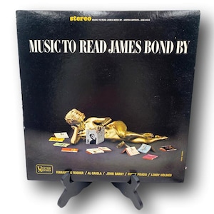 May include: Vintage vinyl record album cover for "Music to Read James Bond By." The black cover features gold-toned artwork of a reclining figure and the album title in white. The United Artists logo is visible.