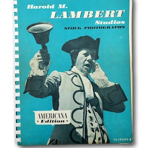 Puede incluir: Una portada de libro vintage con fondo turquesa con el texto "Harold M. Lambert Studios STOCK PHOTOGRAPHS" y "AMERICANA Edition". La portada muestra a un hombre con atuendo colonial sosteniendo una campana.