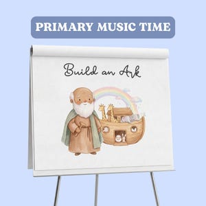 Könnte beinhalten: Ein weißes Flipchart auf einem Ständer mit dem Text PRIMARY MUSIC TIME oben und Build an Ark darunter. Die Illustration zeigt eine bärtige Figur in brauner Robe und grünem Umhang neben einer hölzernen Arche mit Giraffen, Elefanten und einem Kaninchen unter einem Regenbogen.