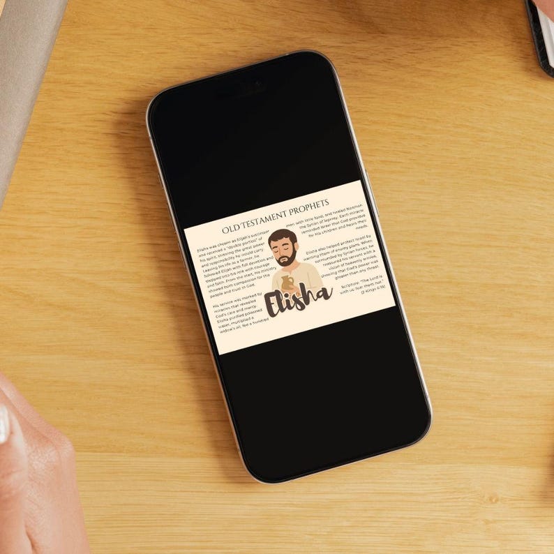 May include: A smartphone displays a graphic about Old Testament Prophet Elisha. The graphic features an illustration of Elisha with text describing his life and ministry. The phone rests on a wooden surface.