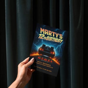 Puede incluir: Una invitaci&oacute;n de cumplea&ntilde;os con el texto "MARTY'S 12TH BIRTHDAY" en oro y azul. La invitaci&oacute;n presenta una ilustraci&oacute;n de un coche DeLorean con rayos y la fecha 23 de agosto de 2025. Incluye direcci&oacute;n e informaci&oacute;n RSVP.
