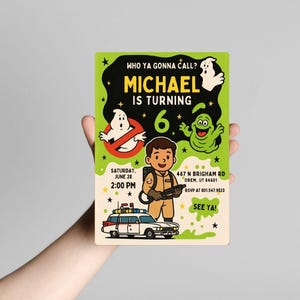 May include: A rectangular invitation card with a green background and cartoon illustrations. The card features the text "WHO YA GONNA CALL? MICHAEL IS TURNING 6" and other details. A cartoon character in a Ghostbusters uniform is holding a weapon.