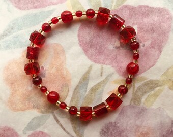 Pte-109 Bracelet ruby red light gold stretch 8 inches. Free Shipping.