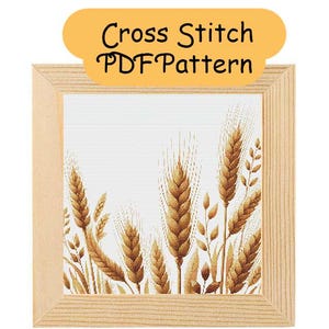 May include: A cross-stitch PDF pattern depicting wheat. The design is framed in a light wood frame. The wheat stalks are in shades of brown and gold against a white backdrop. The text "Cross Stitch PDF Pattern" is displayed at the top.