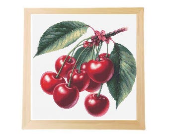 May include: A framed cross-stitch embroidery of a branch of cherries with green leaves and red cherries.