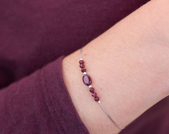 Bracelet with thin and fluid steel chain and small faceted garnet beads