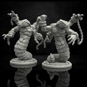 Puede incluir: Dos figuras grises con textura de piedra, con forma de serpiente, con brazos y manos, encadenadas a las muñecas. Cada figura se apoya sobre una base circular. Las figuras tienen cabeza de reptil y cuerpo segmentado. El fondo es negro.