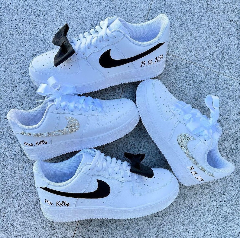 May include: Three white sneakers with black swooshes. The sneakers are personalized with the text "Mrs. Kelly", "Mr. Kelly", and "29.06.2023".