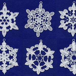 Puede incluir: Seis adornos de copo de nieve blancos con diseños intrincados, cada uno con un lazo para colgar. Los copos de nieve están sobre un fondo azul.