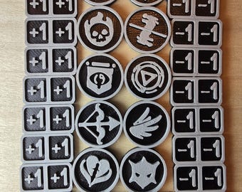 May include: A set of 20 black and gray plastic tokens with various symbols and numbers. The tokens are arranged in rows and columns. The symbols include a crescent moon, a dragon, a skull, a horse, an eye, a triangle, a bow and arrow, a wing, a heart, and a cat. The numbers are +1+1 and -1-1.