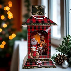 Puede incluir: Una linterna navideña decorativa con un patrón de cuadros rojos y negros. En el interior, Papá Noel y osos de peluche están dispuestos en una escena festiva. Una pequeña figura de Papá Noel se encuentra en la base, con un árbol de Navidad y adornos en el fondo.