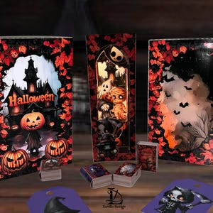 Könnte beinhalten: Halloween-Dekorationen mit einem Spukhaus, Kürbis-Motiven und Miniaturbüchern. Die Farbpalette umfasst Orange, Schwarz und Rot, mit dem Wort "Halloween" deutlich sichtbar. Zusätzliche Anhänger und ein zentrales Ausstellungsstück sind ebenfalls vorhanden.
