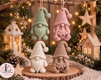 Op de afbeelding: Vier kabouterornamenten met een textuur van gebreid patroon. Twee kabouters hebben lange baarden en twee hebben gevlochten haar met een ster op hun borst. De kleuren zijn saliegroen, zachtroze, crème en beige. Elke kabouter draagt een puntmuts met een pompon.