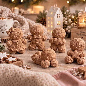 May include: A collection of five light brown knitted gingerbread-style figures in various poses. One figure wears a bow, another holds a heart, and one holds a star. The figures are arranged on a wooden surface alongside a white mug with the text Winter Zauber, a small white house, and a wooden block with the text Kleine Glücksmomente.
