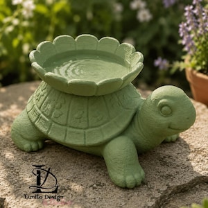 May include: A light green turtle-shaped garden ornament featuring a shallow, scalloped-edge basin on its back for holding water. The turtle has a textured surface and a smiling expression. The logo for Lunito Design is visible in the corner.